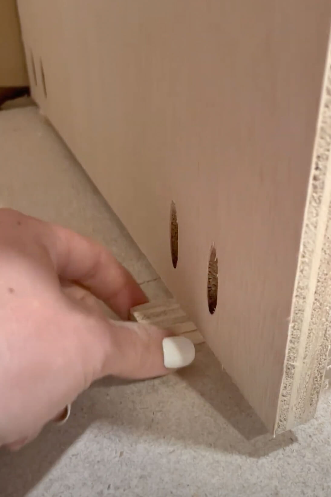 Using a shim to raise the height of the cabinet off of the floor.